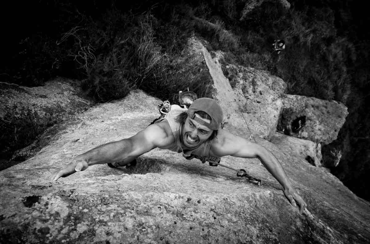 Rock climber leaping for a ledge seen from above